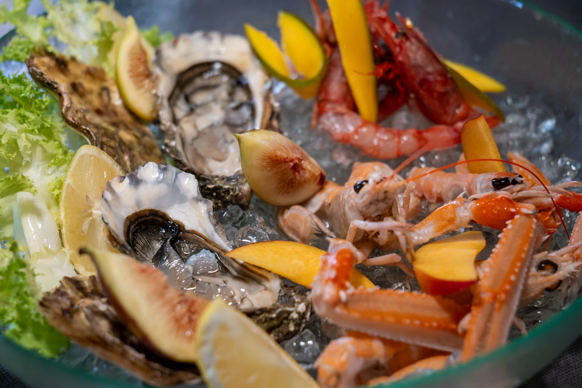 Crudité di mare con ostriche, scampi e gamberi rossi su ghiaccio, con fichi, pesca e limone