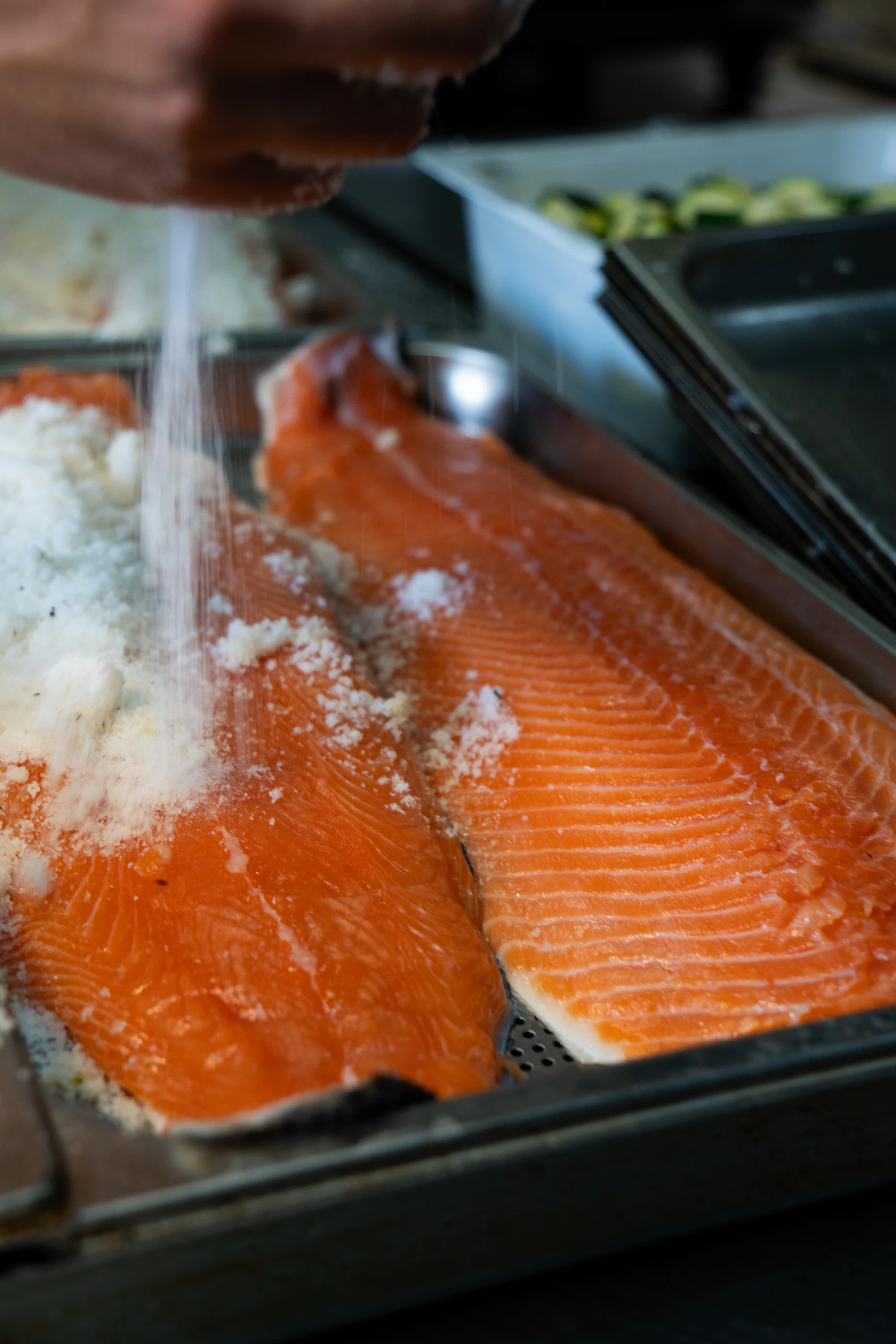Due filetti di salmone fresco in teglia, preparati con pepe e limone
