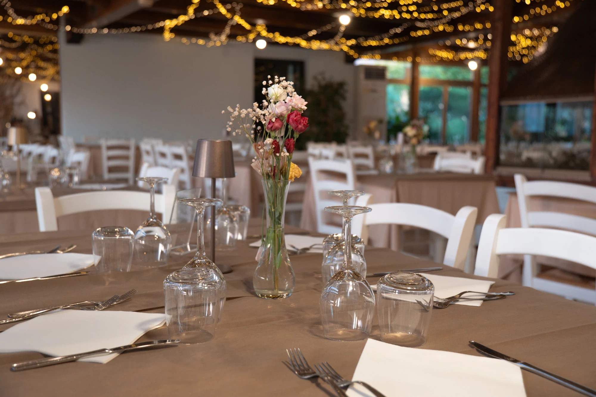 Sala da pranzo di Le Mimose apparecchiata con luci calde e rose